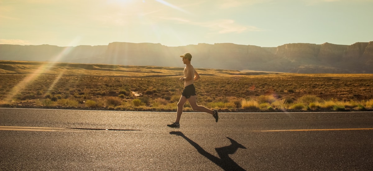 Man running outdoors during a 30-day morning cardio stamina challenge